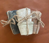 Three bars of soap tied together with twine on a saddle tan leather background