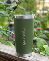 [Eastern Pine Green] insulated tumbler with silver lid on a wooden surface with a natural background