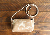 Cowhide Crossbody Saddle Bag back view features a unique pattern of shades of cream, khaki, and chocolate. Shown in color [Cowhide A].