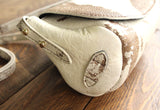 Cowhide Crossbody Saddle Bag side view features the adjustable strap and strap keeper. Shown in color [Cowhide C].