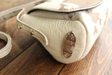 Cowhide Crossbody Saddle Bag side view features the adjustable strap and strap keeper. Shown in color [Cowhide E].
