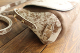 Cowhide Crossbody Saddle Bag side view features the adjustable strap and strap keeper. Shown in color [Cowhide F].