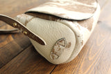 Cowhide Crossbody Saddle Bag side view features the adjustable strap and strap keeper. Shown in color [Cowhide G].
