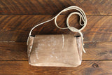 Cowhide Crossbody Saddle Bag back view features a unique pattern of shades of cream, khaki, and chocolate. Shown in color [Cowhide I].