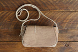 Cowhide Crossbody Saddle Bag front view features a unique pattern of shades of cream, khaki, and chocolate. Shown in color [Cowhide I].